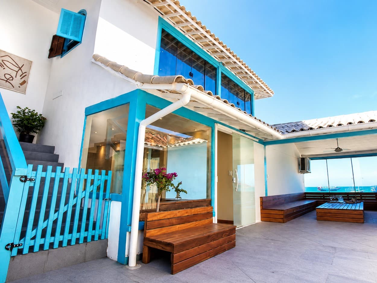 Área externa da pousada com arquitetura branca e azul